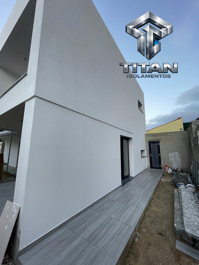 Fachada lateral branca com acabamento liso de capoto e pavimento exterior