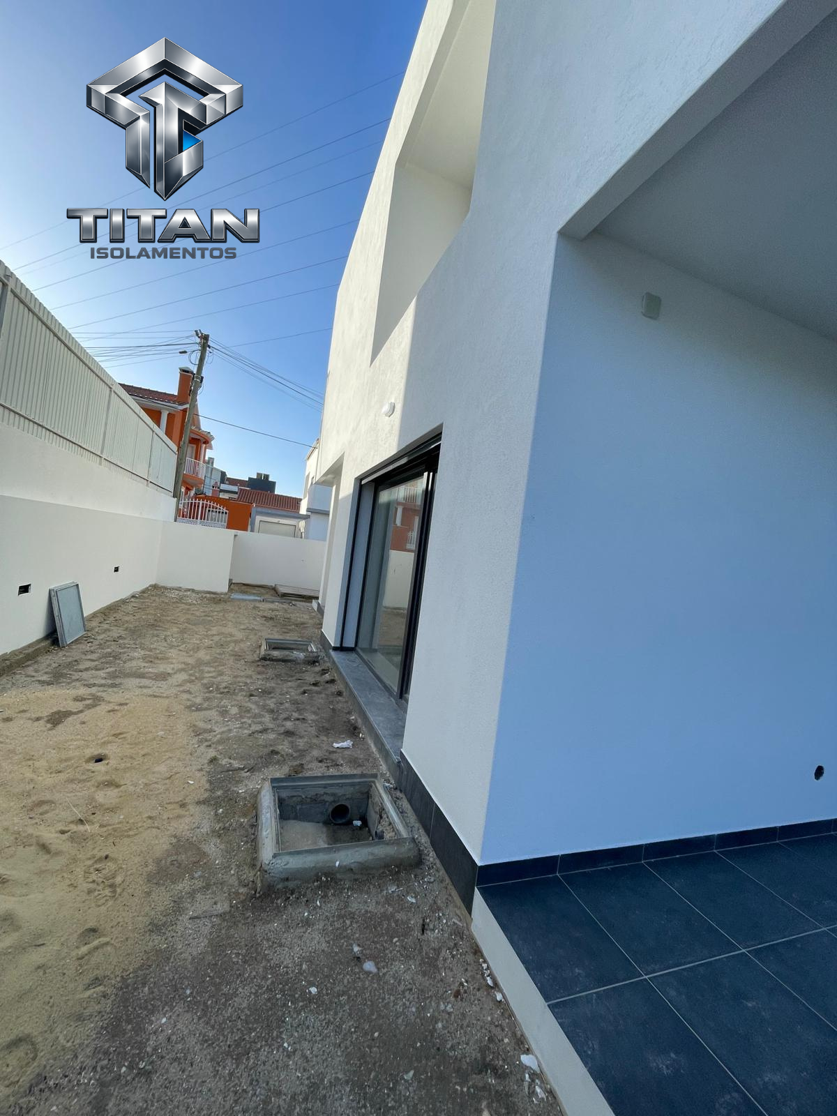 Vista lateral de moradia com fachada branca isolada e passagem exterior